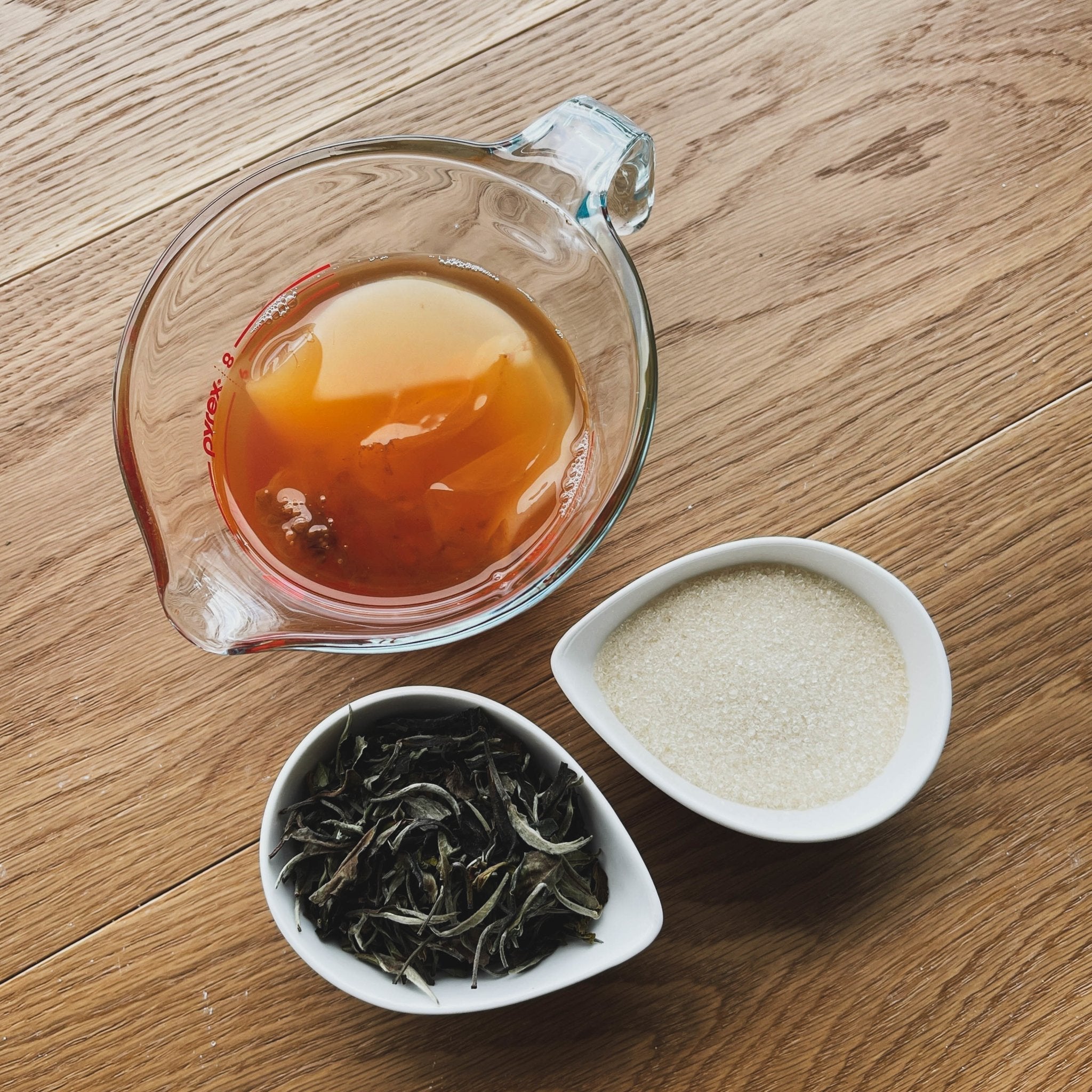 Premium loose leaf tea with brewed tea in glass teapot for kombucha brewing and natural wellness ritual