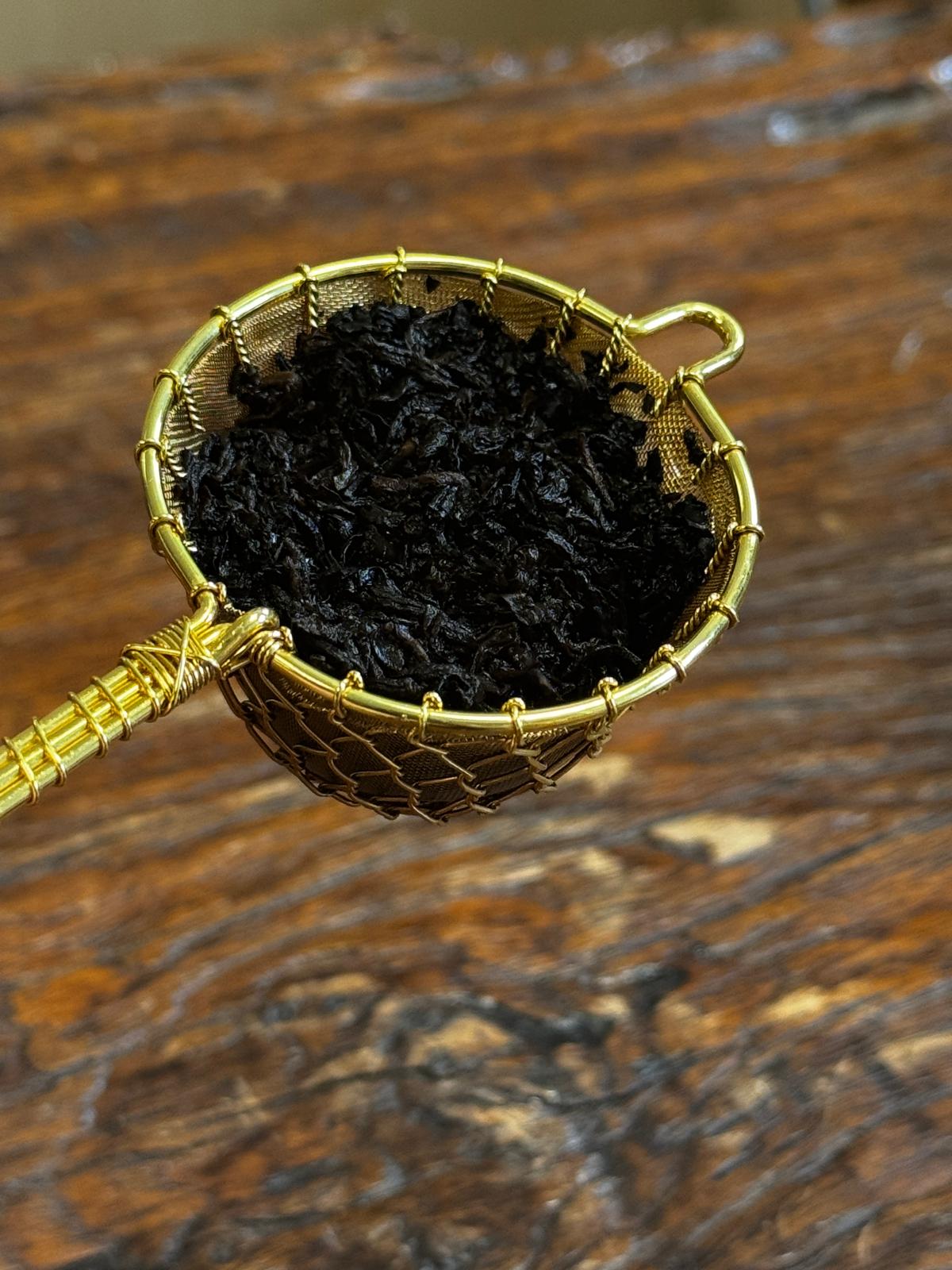 Close-up of organic Pu-erh tea leaves after infusion, revealing dark expanded fermented leaves prized for their earthy flavor and traditional Chinese tea heritage.